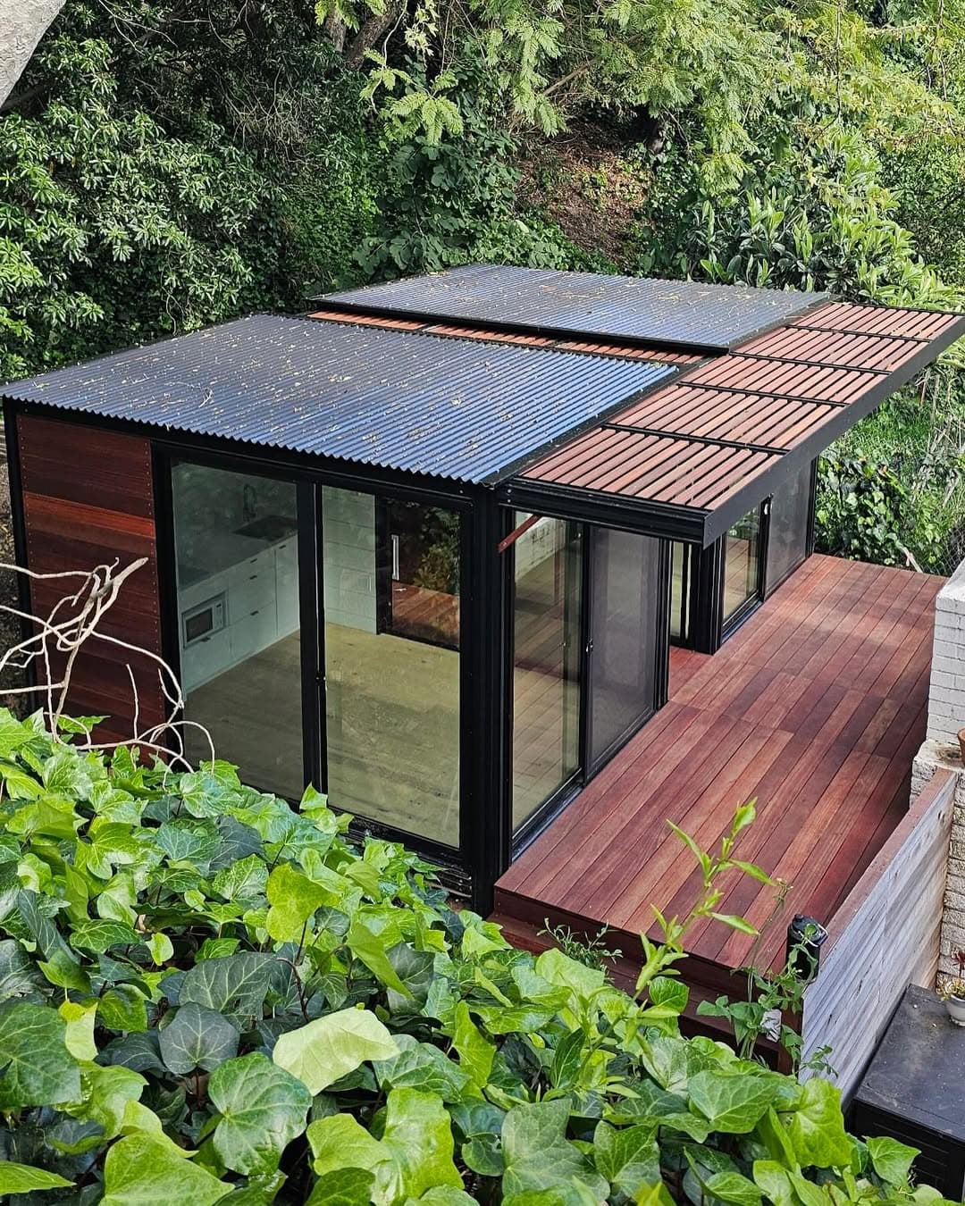 L-shaped custom home with solar panels, aerial view