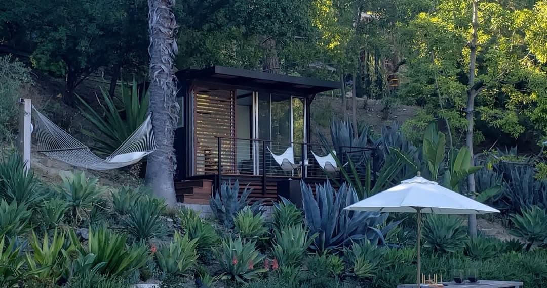 Dark-frame cabin with panoramic glass and hammock deck